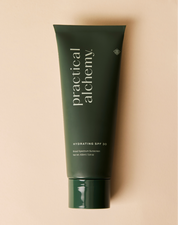 Green tube of Practical Alchemy hydrating SPF 30 sunscreen on a beige background