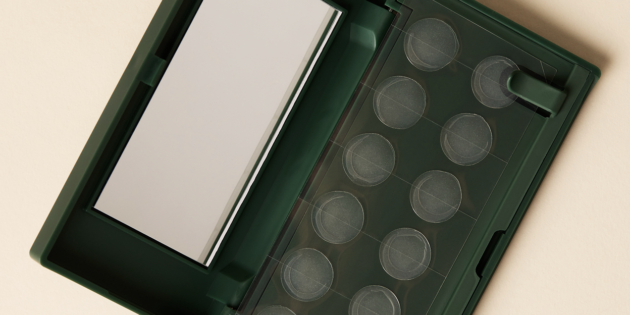 An open Just in Case pimple patch carrying case with mirror on a beige background