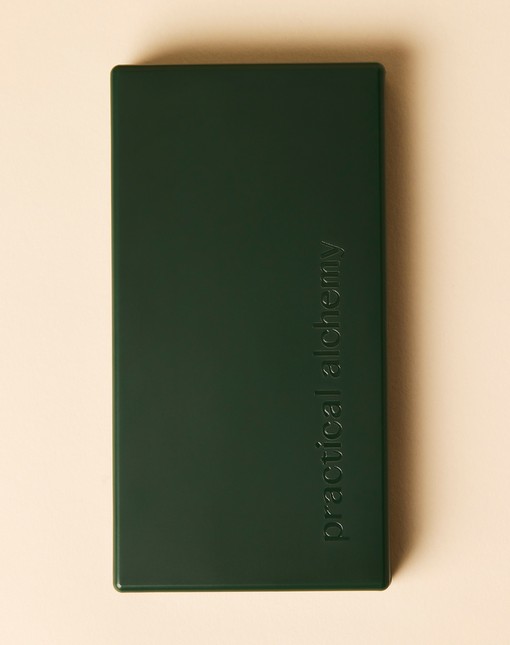 Green Just in Case pimple patch carrying case with 'practical alchemy' embossed on a beige background