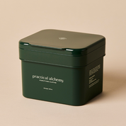 Closed green container of Practical Alchemy Purifying Clothes on a beige background